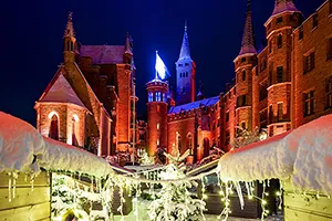Verschneiter und beleuchteter Weihnachtsmarkt in der Nacht in der Burg Hohenzollern