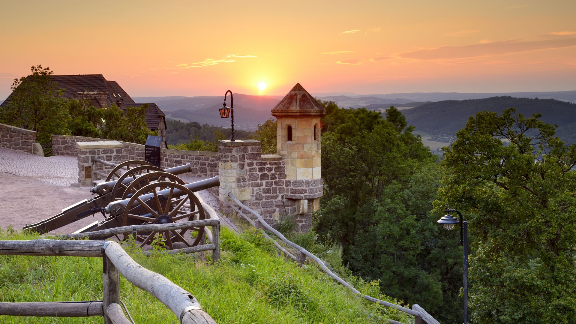 Eisenach: View over two cannons in front of the Wartburg castle to the sunset in the Thuringian Forest