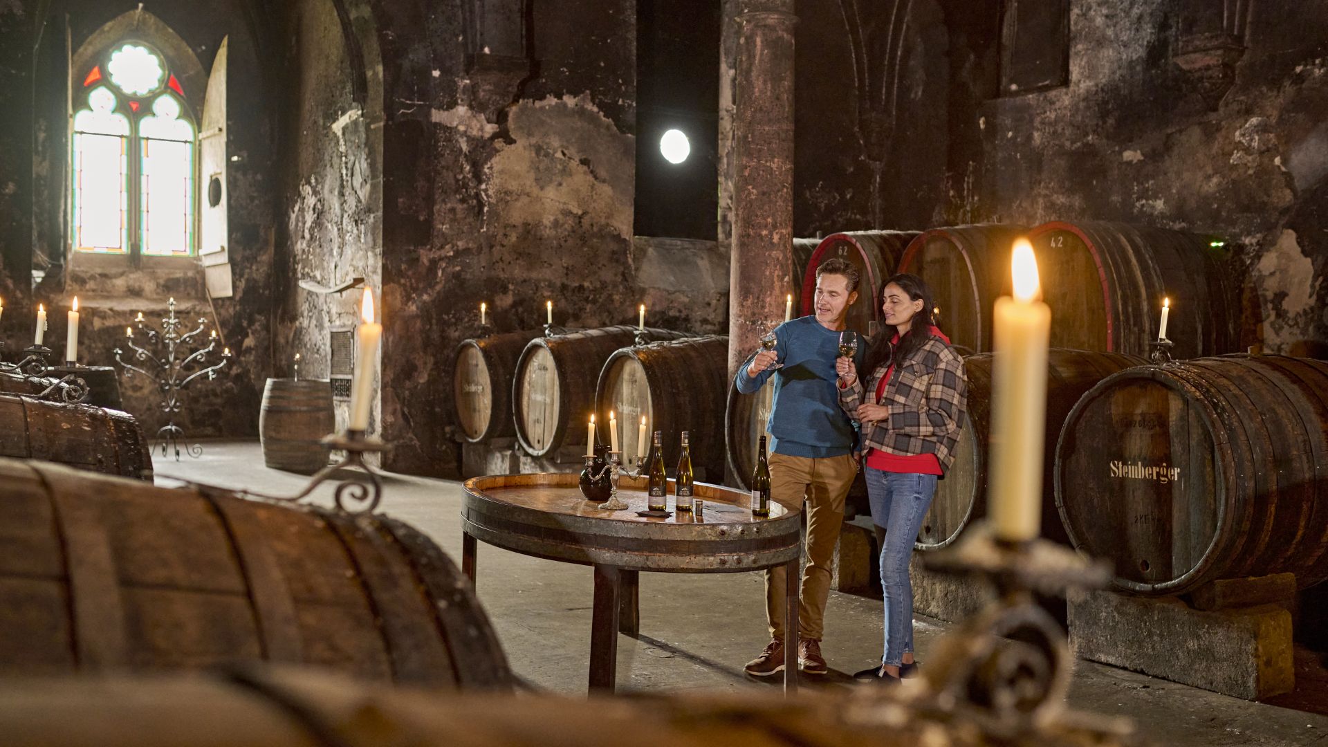 Two people in the wine cellar of Eberbach Monastery for wine tasting