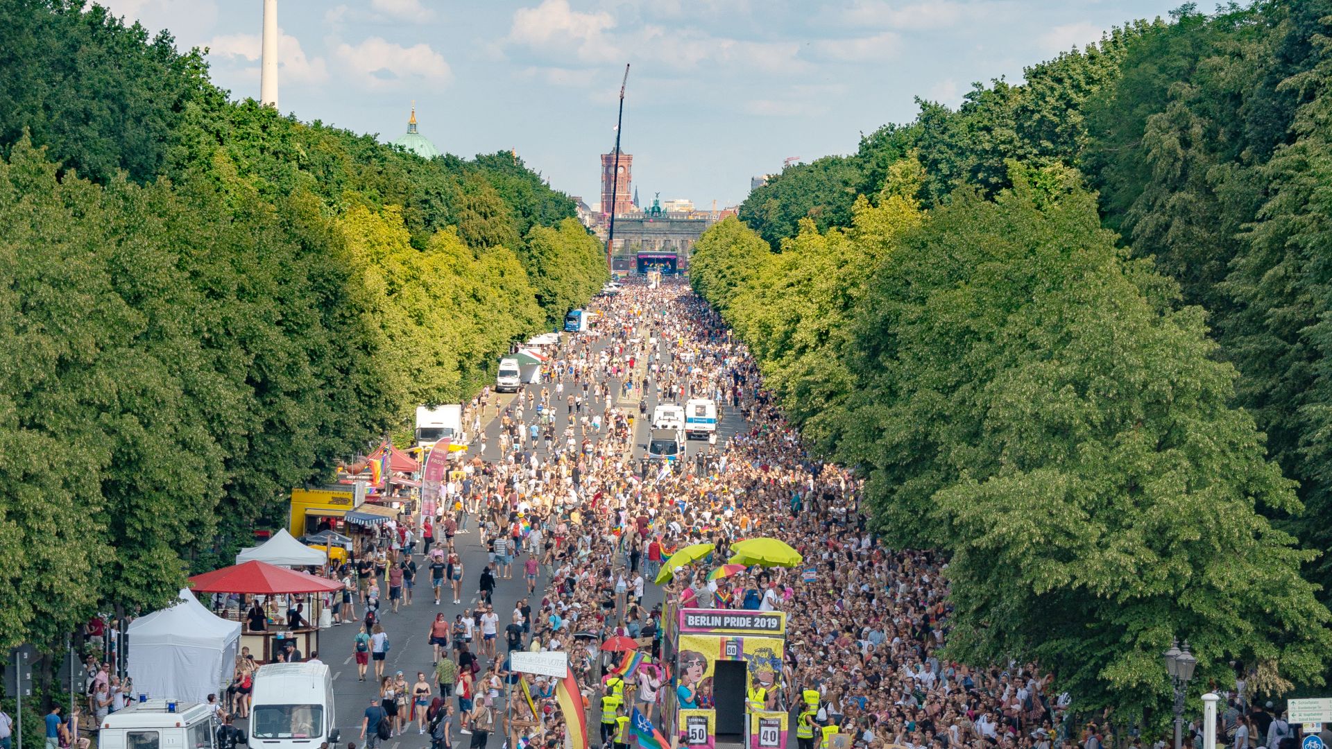 A large crowd with rainbow flags gathers on the street in Berlin for Christopher Street Day