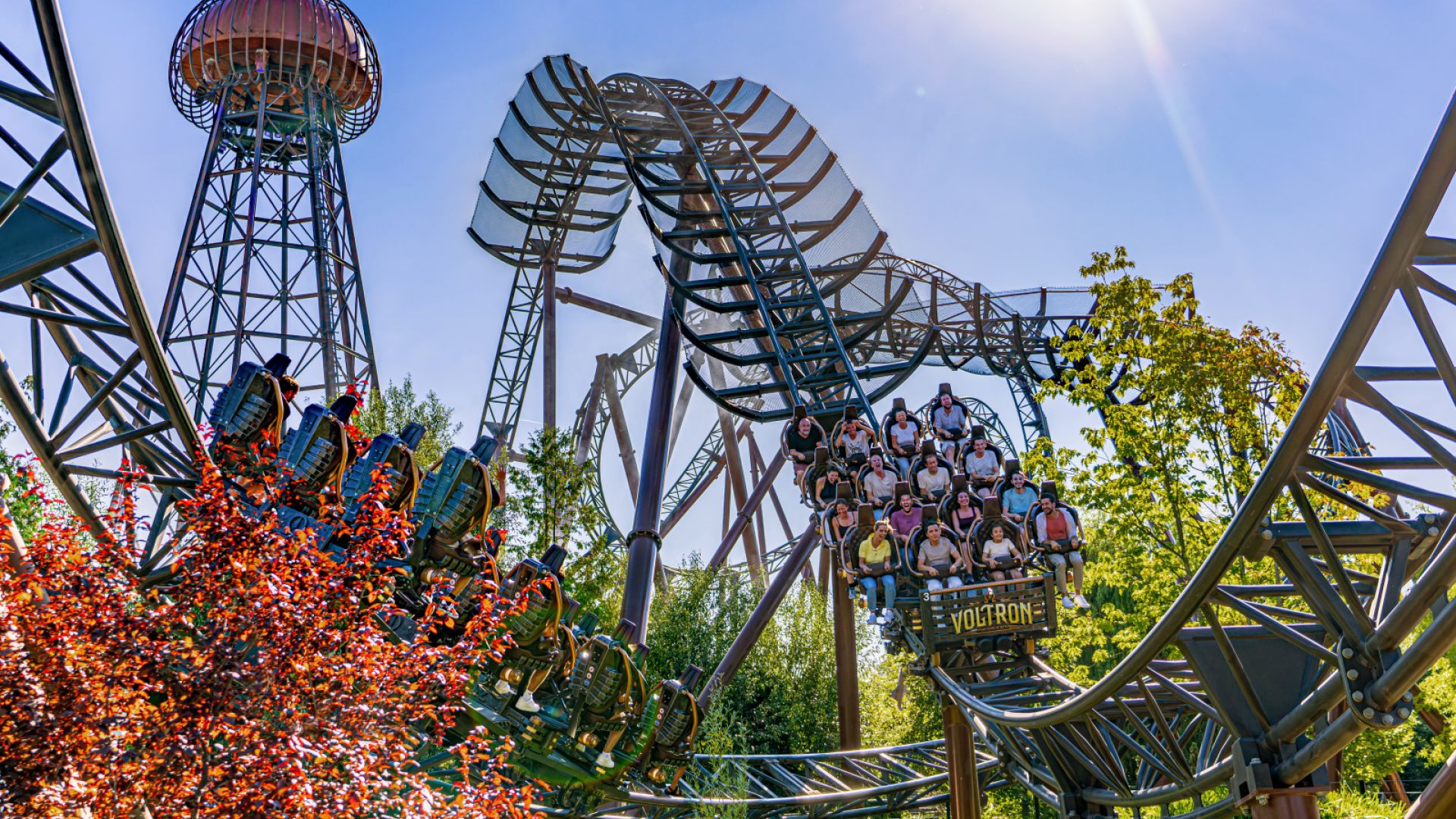 voll besetzte Achterbahn im Sonnenlicht