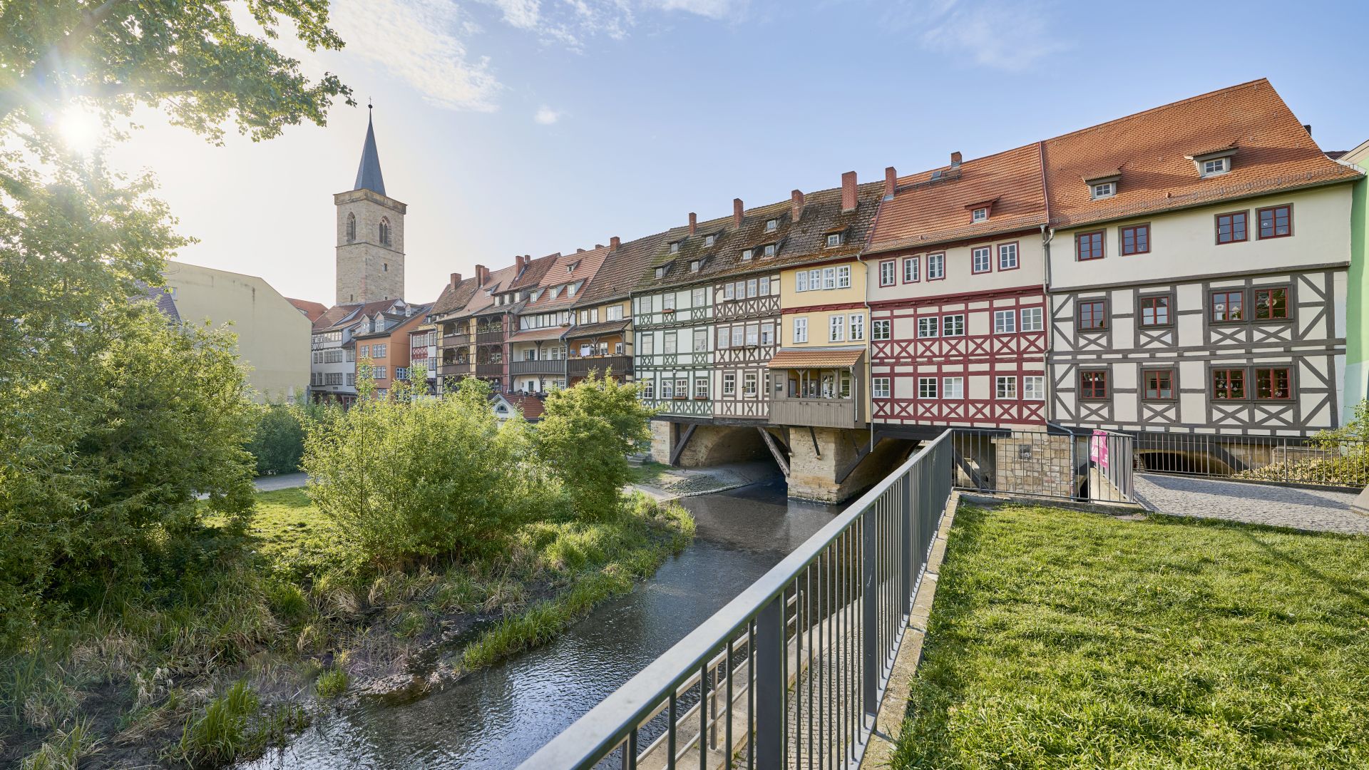 View of the half-timbered houses on the Krämerbrücke under a blue sky and sunshine