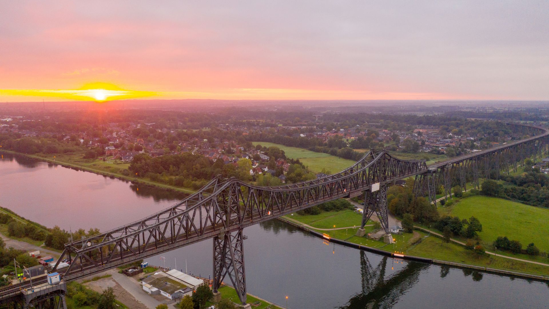 Aerial view of a railroad bridge over a river at sunset