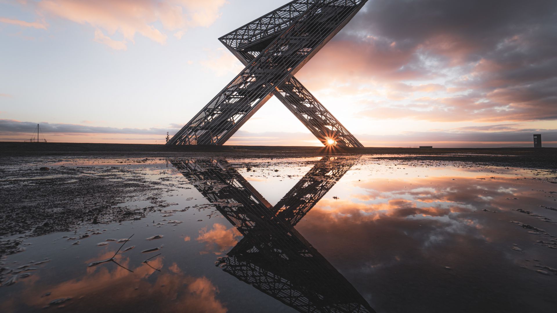 Das Saarpolygon steht auf der Bergehalde Duhamel in Ensdorf, Saarland. Die Metallkonstruktion wurde bei Sonnenuntergang aufgenommen, wobei die Sonne durchscheint.