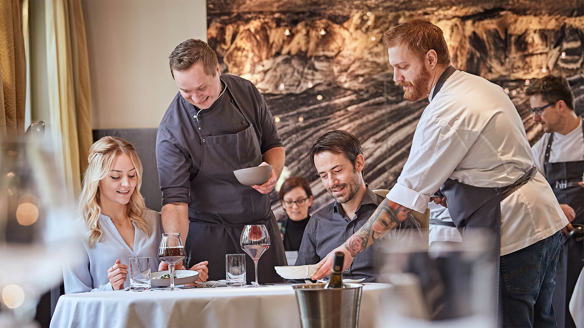 At the Posthotel Alexander Herrmann in Wirsberg, two waiters serve food to two guests