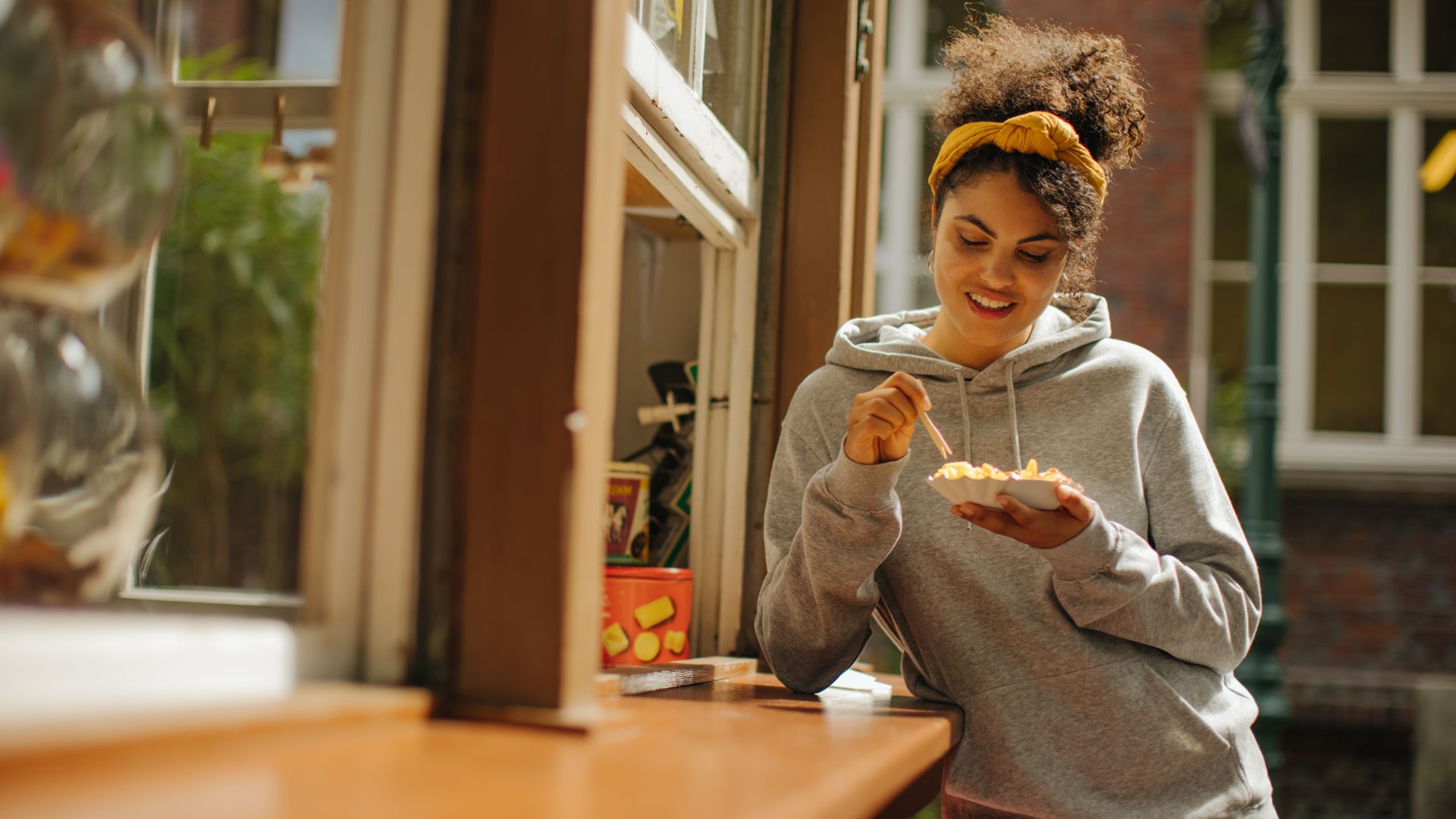 Eine Frau isst eine Currywurst mit einer kleinen Gabel an der Fortuna-Bude im Heimatmuseum Unser Fritz in Herne