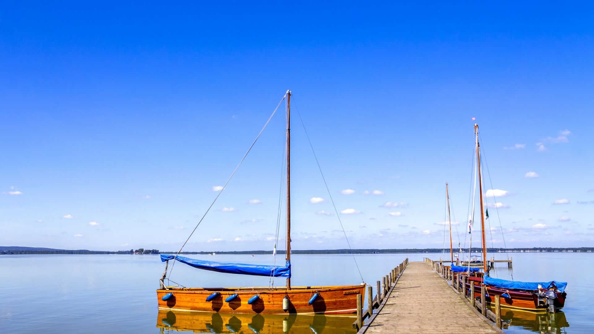 Steinhuder Meer mit leerem Steg und festgemachten Segelbooten