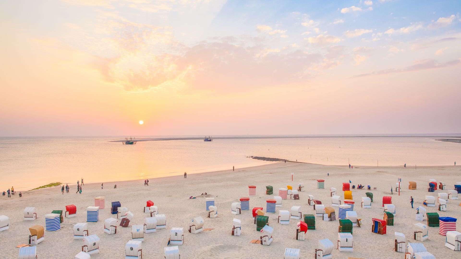 Borkum: Chaises de plage colorées sur l'île de Borkum au coucher du soleil