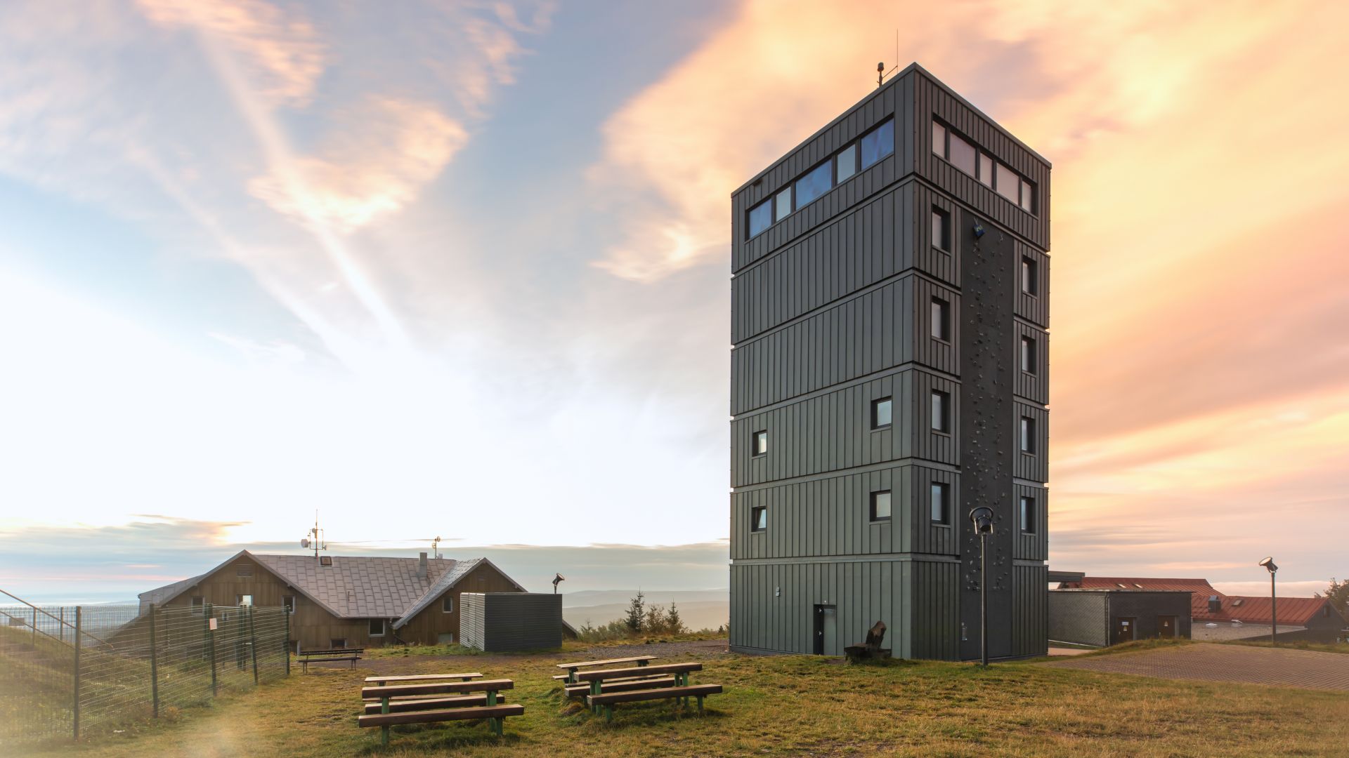 Tower on the Thuringian Inselberg with picnic benches in the foreground and a colorful sunset.