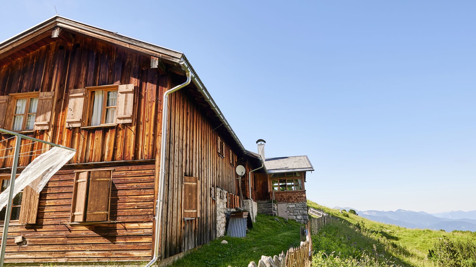 Die Berghüte Schachenhaus aus Holz steht auf einem grasbewachsenen Hügel im Wettersteingebirge bei Garmisch-Partenkirchen.