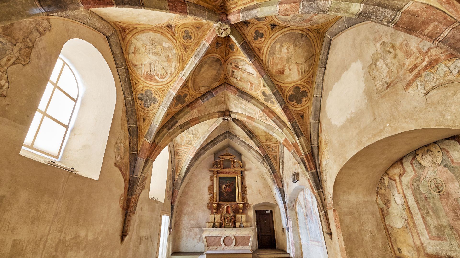 Ein gewölbter Raum mit dekorativen Bögen und komplizierten Deckengemälden wird in der Ausstellung „Faszination Mittelalter“ im Oberhausmuseum in Passau gezeigt.