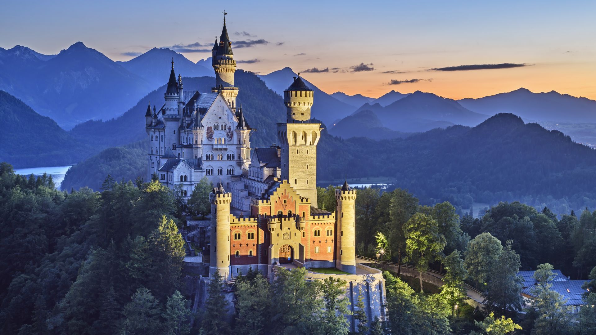 Schwangau: Schloss Neuschwanstein in der Abenddämmerung beleuchtet vor Tannheimer Bergen, Ammergauer Alpen