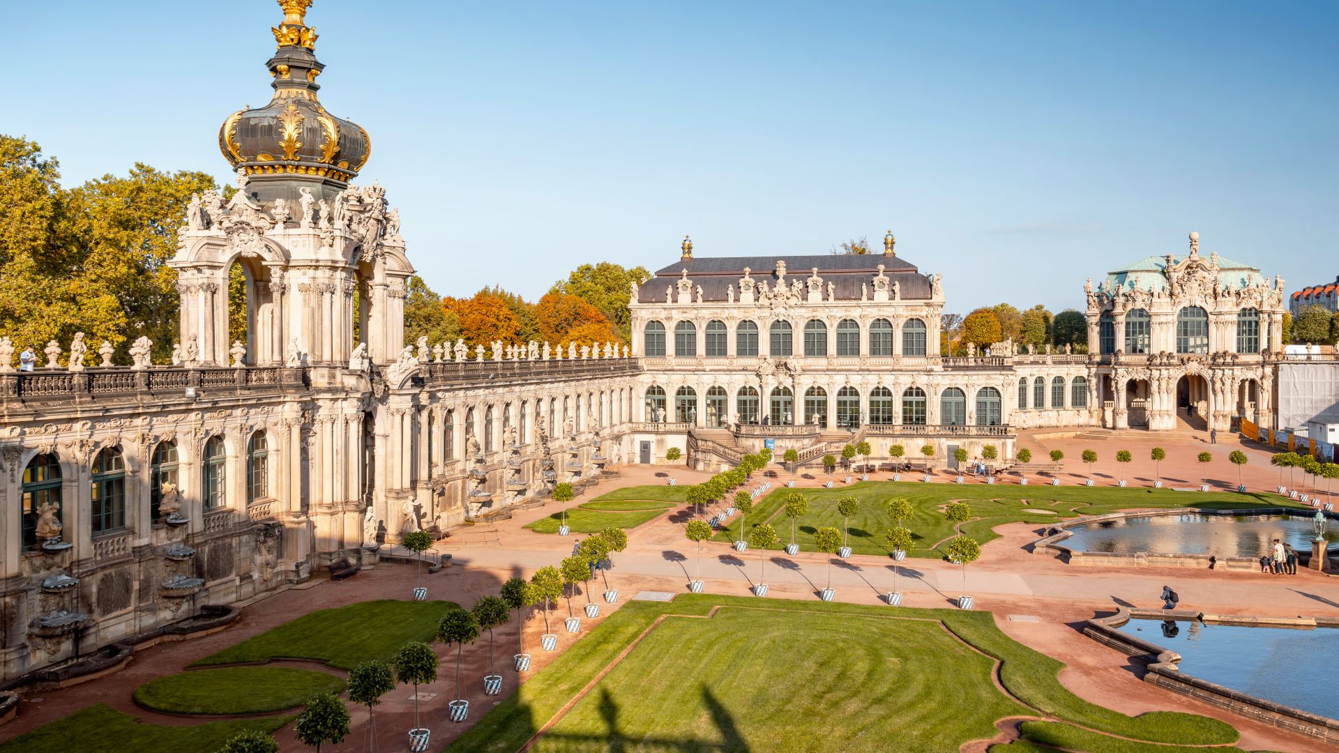 Vue du Zwinger de Dresde avec ses pelouses et ses fontaines dans la cour intérieure par un ciel bleu.