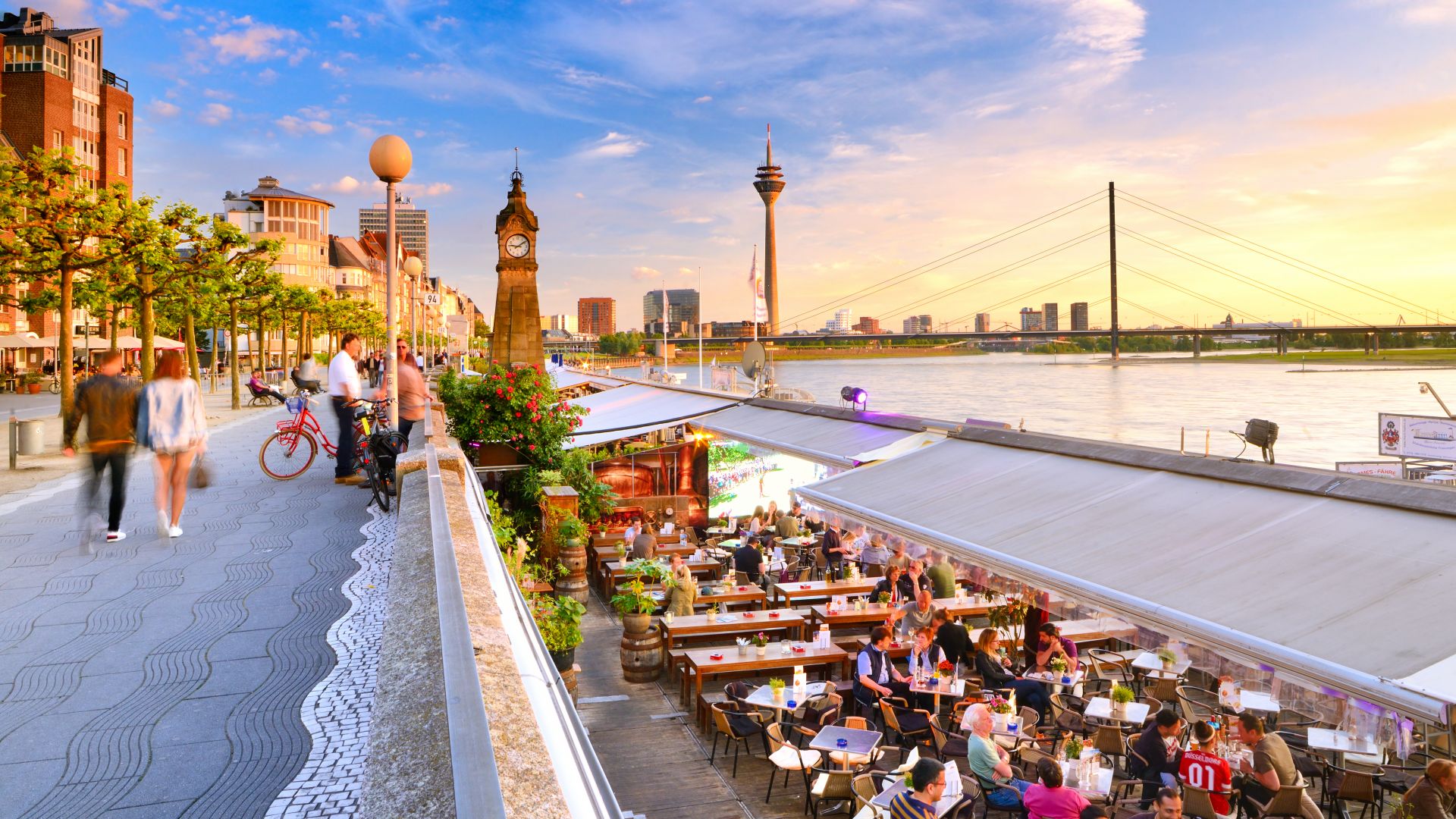 Düsseldorf: Rheinpromenade bei Sonnenuntergang mit dem Rheinturm im Hintergrund