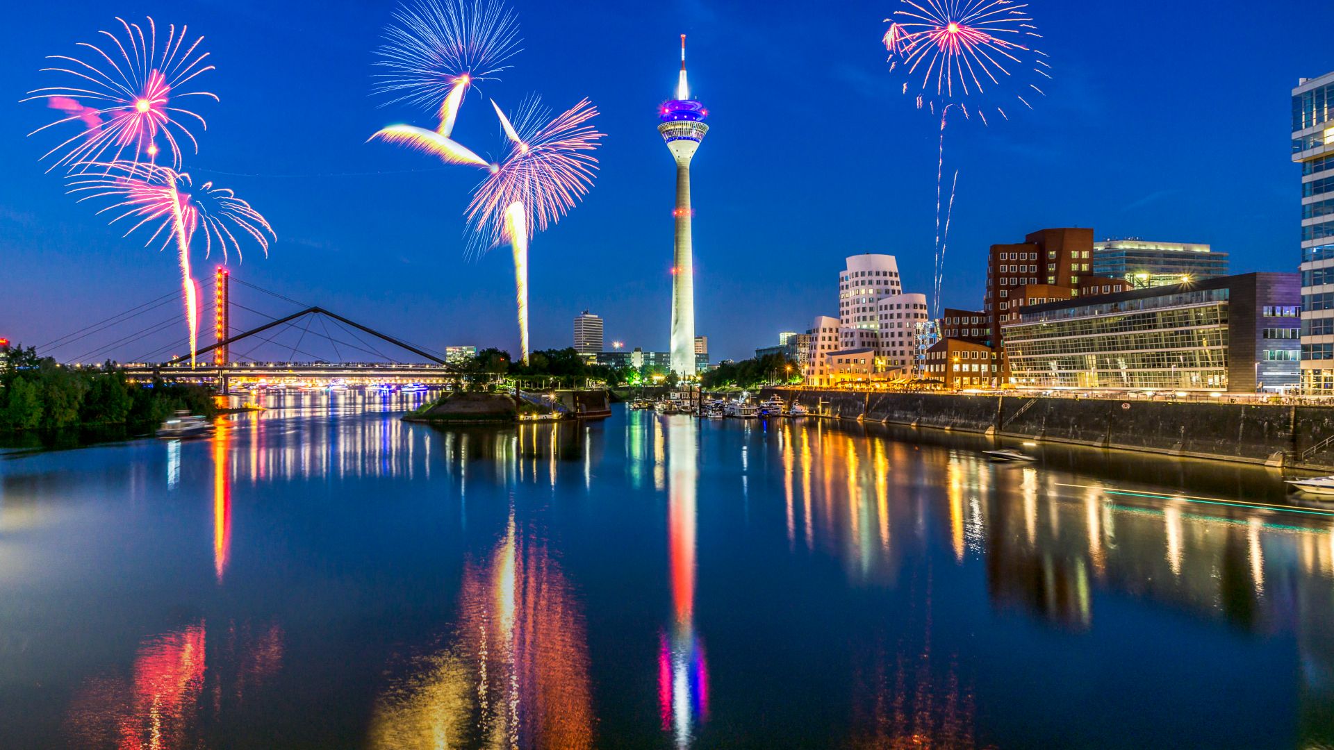 Düsseldorf : feu d`artifice au-dessus du Rhin, en arrière-plan le port des médias avec la tour du Rhin et la nouvelle cour douanière de Frank O`Gehry