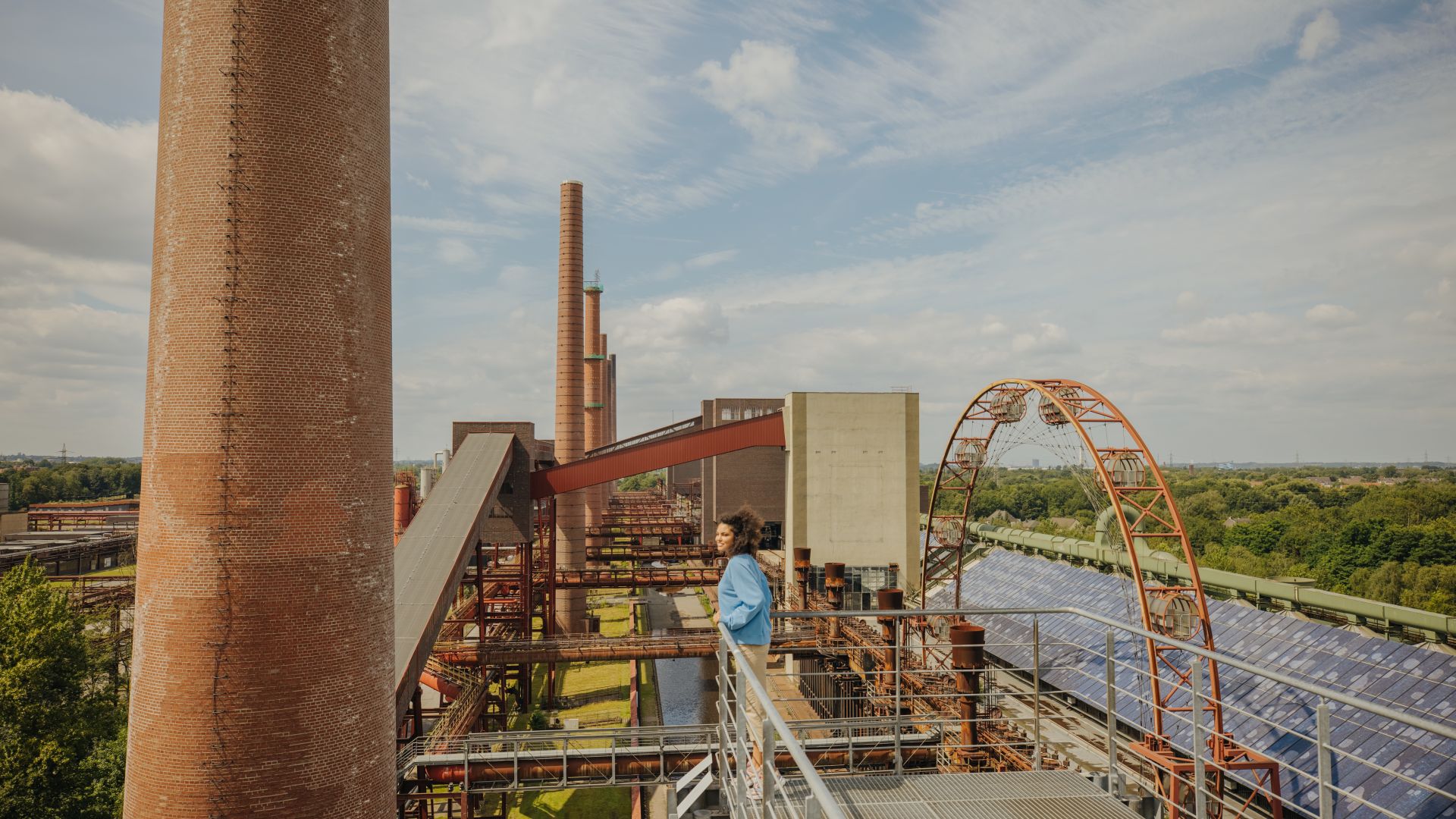 Besucher auf Aussichtsplattform der Zeche Zollverein mit Fördertürmen und Schornsteinen