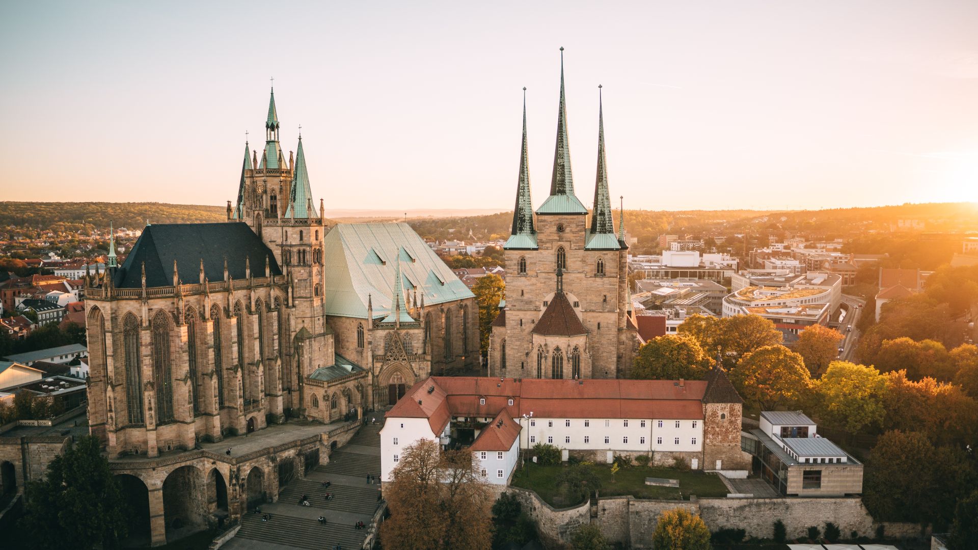 Der Erfurter Dom und die Severikirche im warmen Licht eines Sonnenuntergangs, umgeben von der historischen Stadtlandschaft
