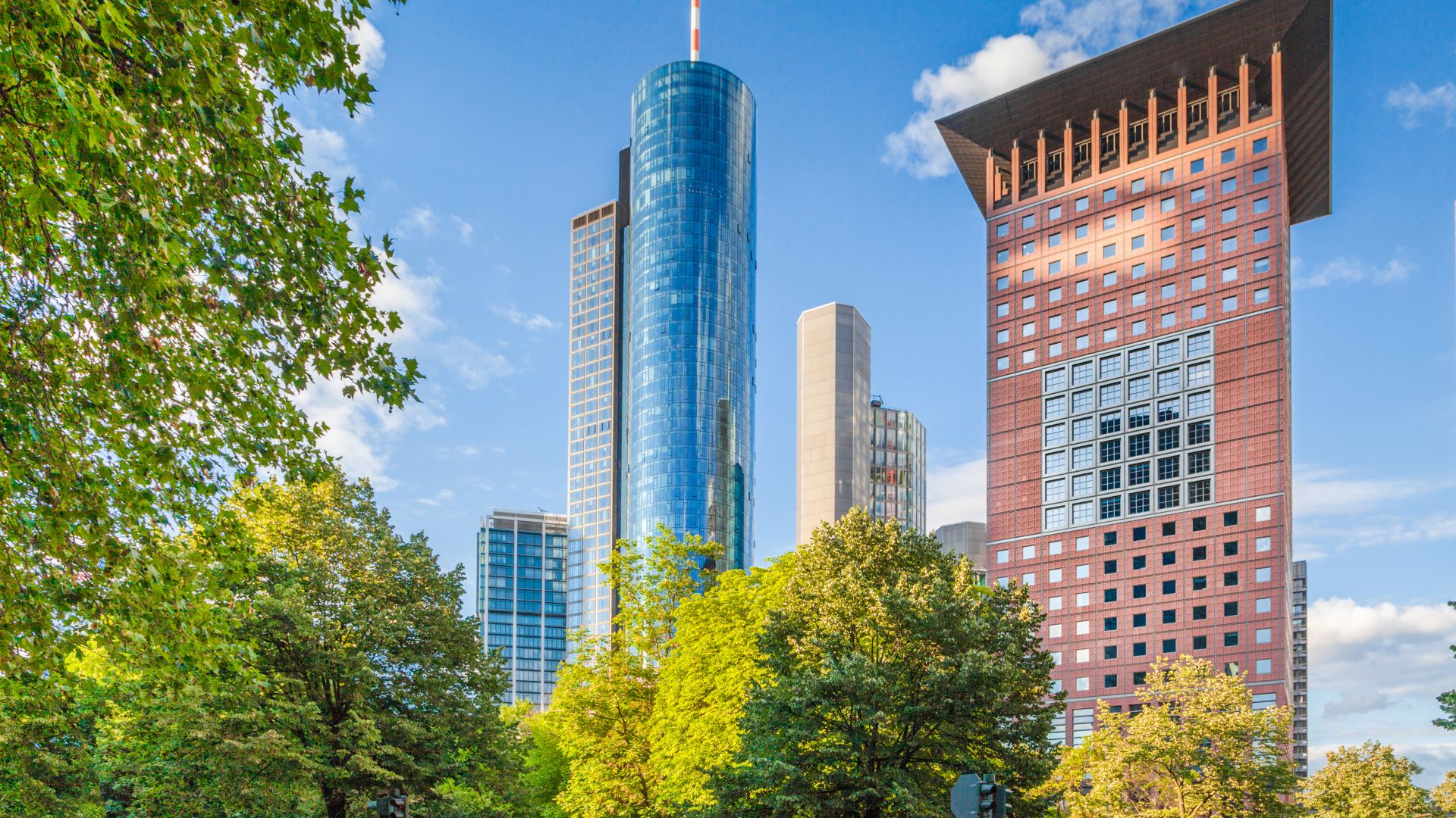 Blick auf die markanten Wolkenkratzer der Frankfurter Skyline, darunter der glänzende Bürokomplex 
