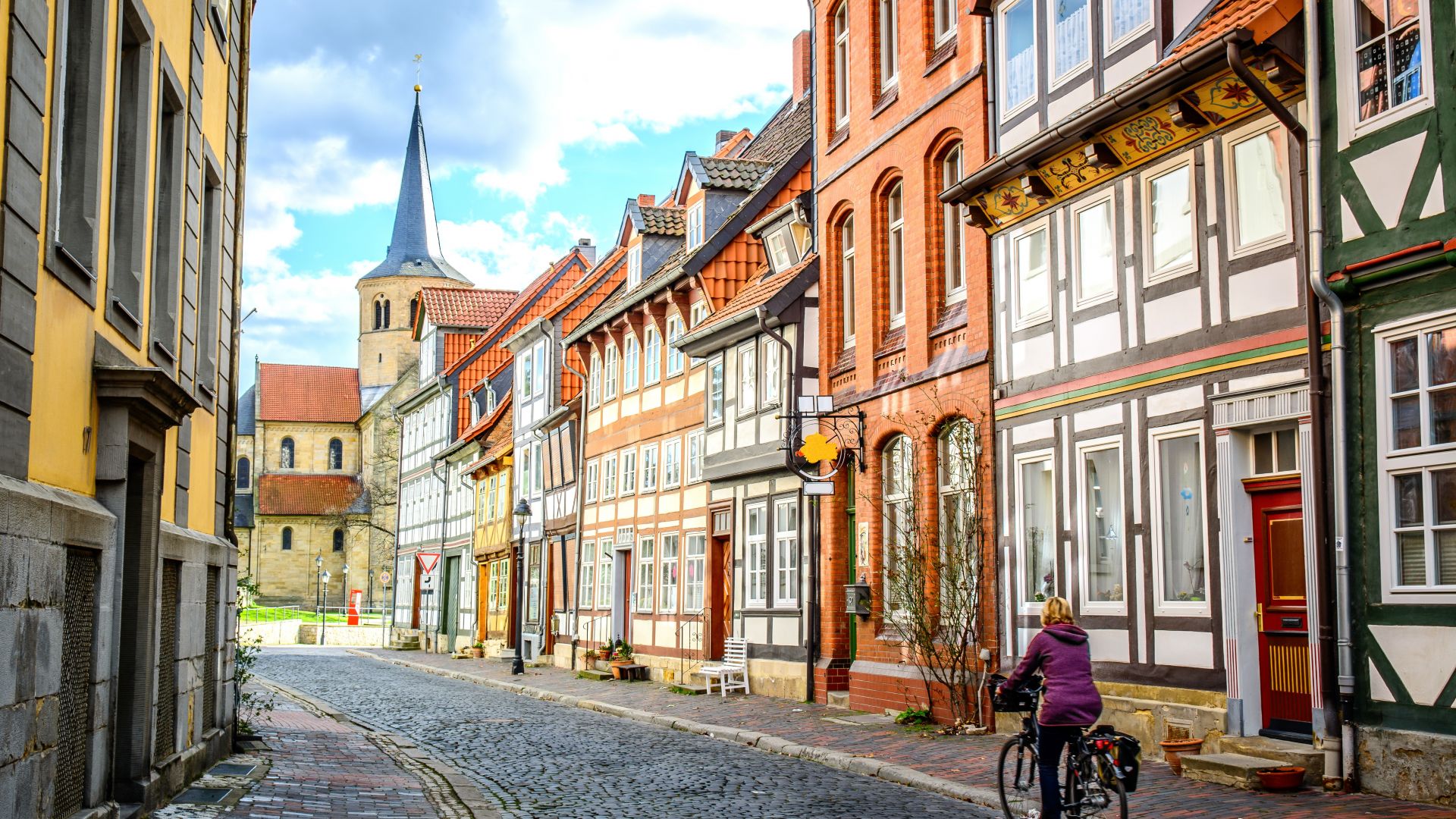 Goslar: Une cycliste traverse une rue avec des maisons à colombages