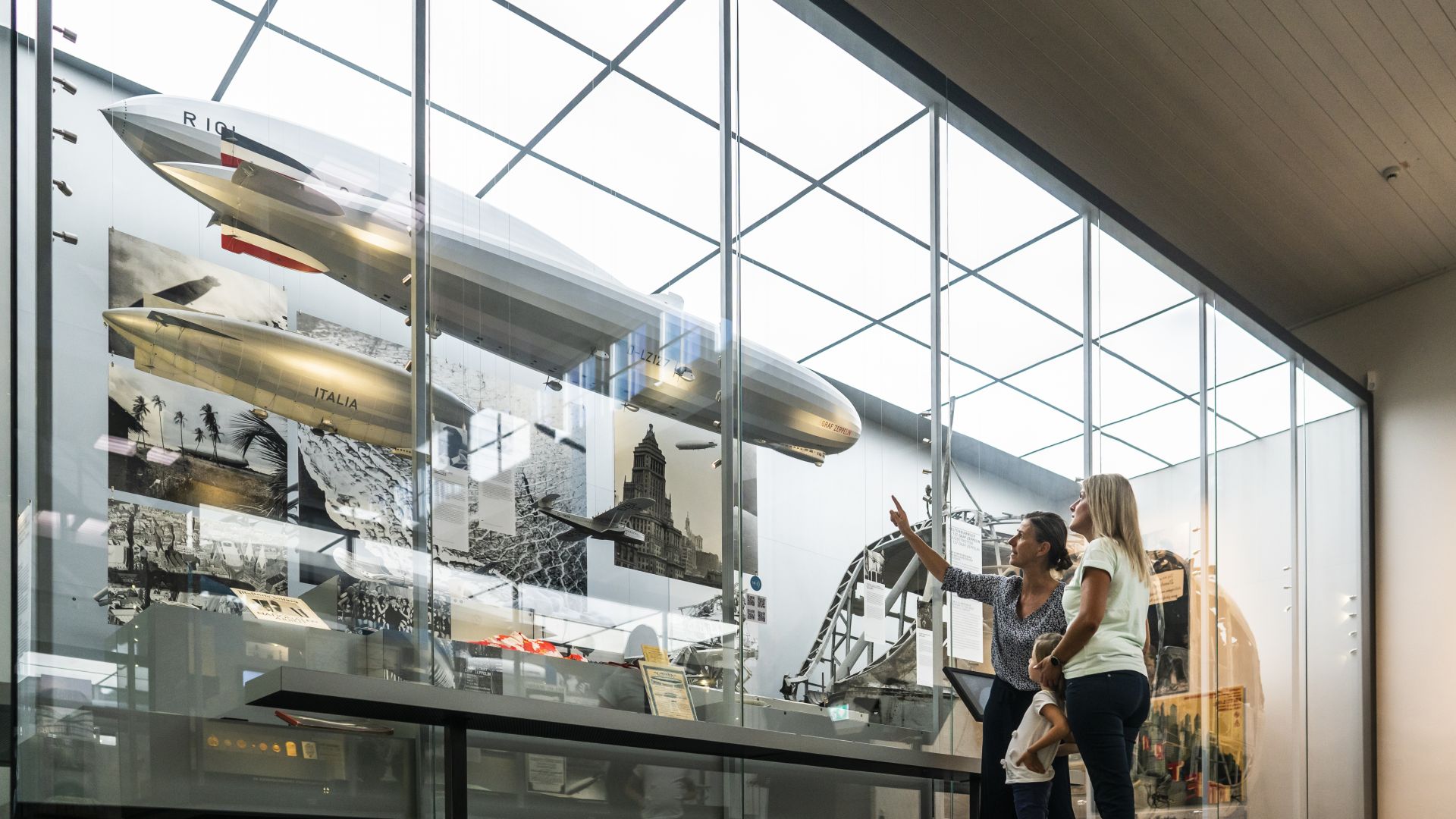 Friedrichshafen : une femme explique le zeppelin à une mère et son enfant au musée Zeppelin