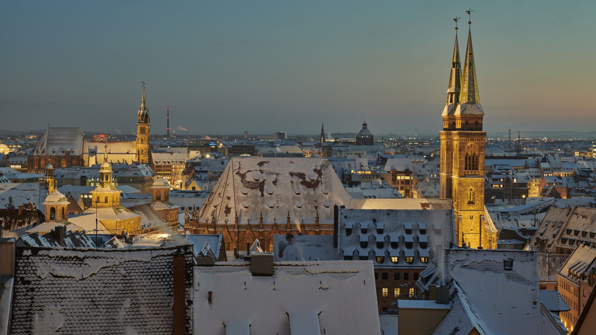 Die schneebedeckten Dächer der Nürnberger Altstadt mit ihren mittelalterlichen Gebäuden und Kirchtürmen.