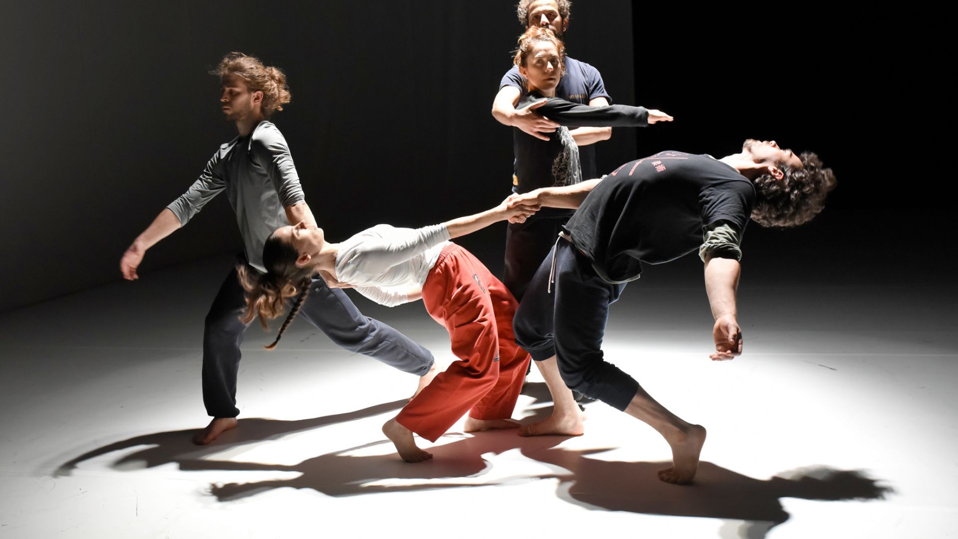 four people perform a dance in a minimalist setting